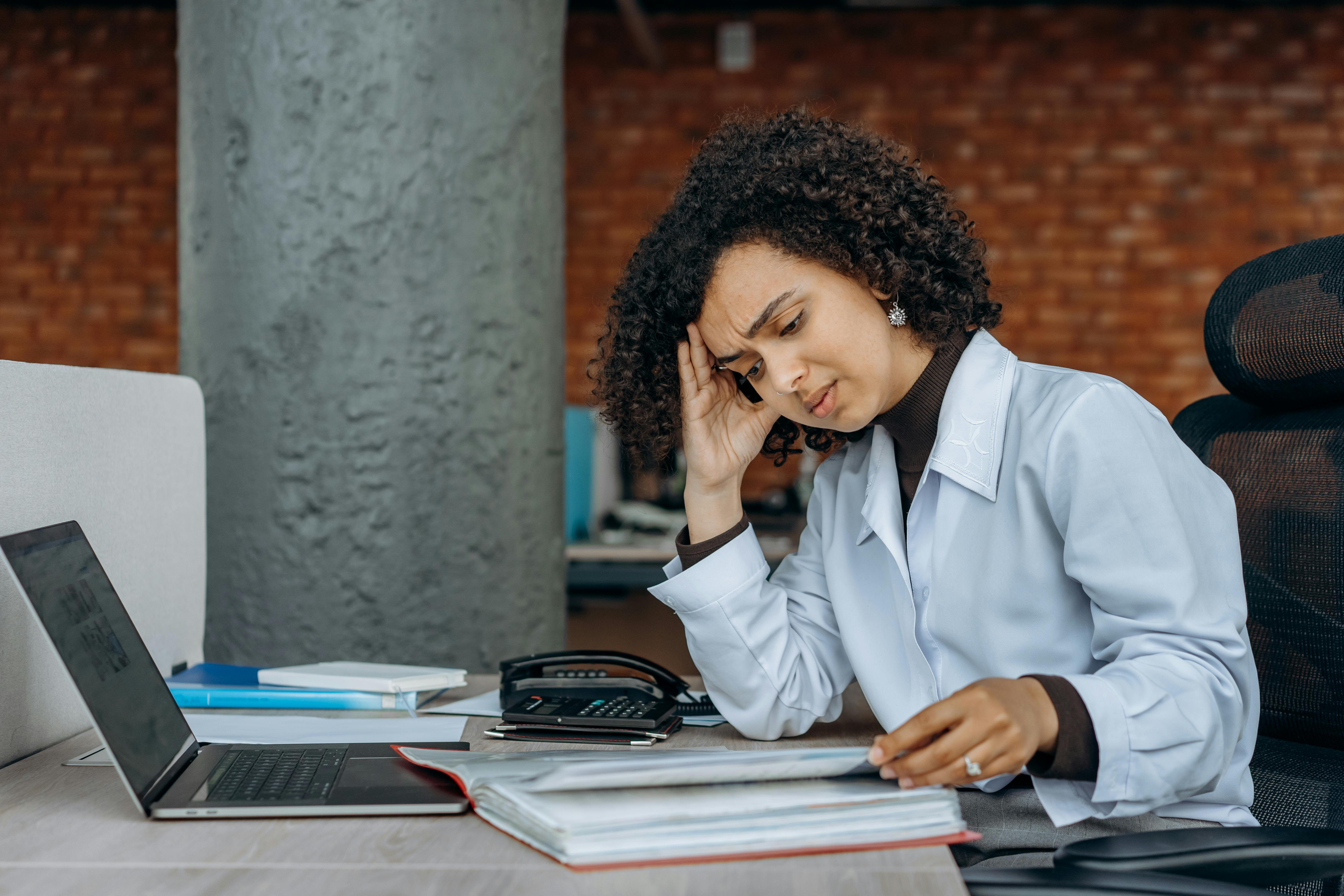 Woman Stressed Out Looking At Papers And Laptop